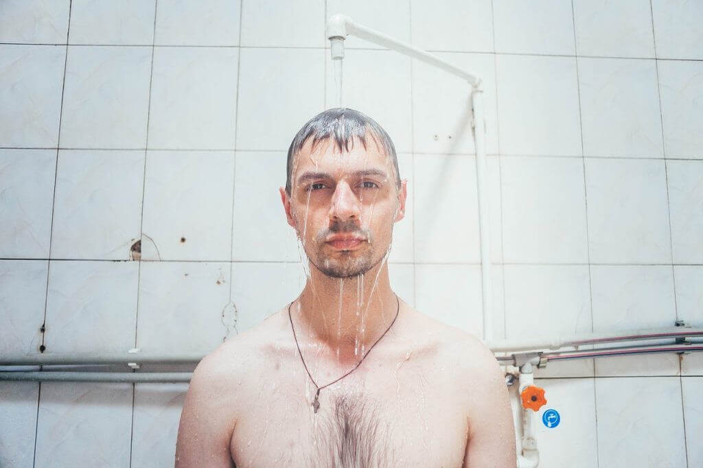 Man standing under shower.