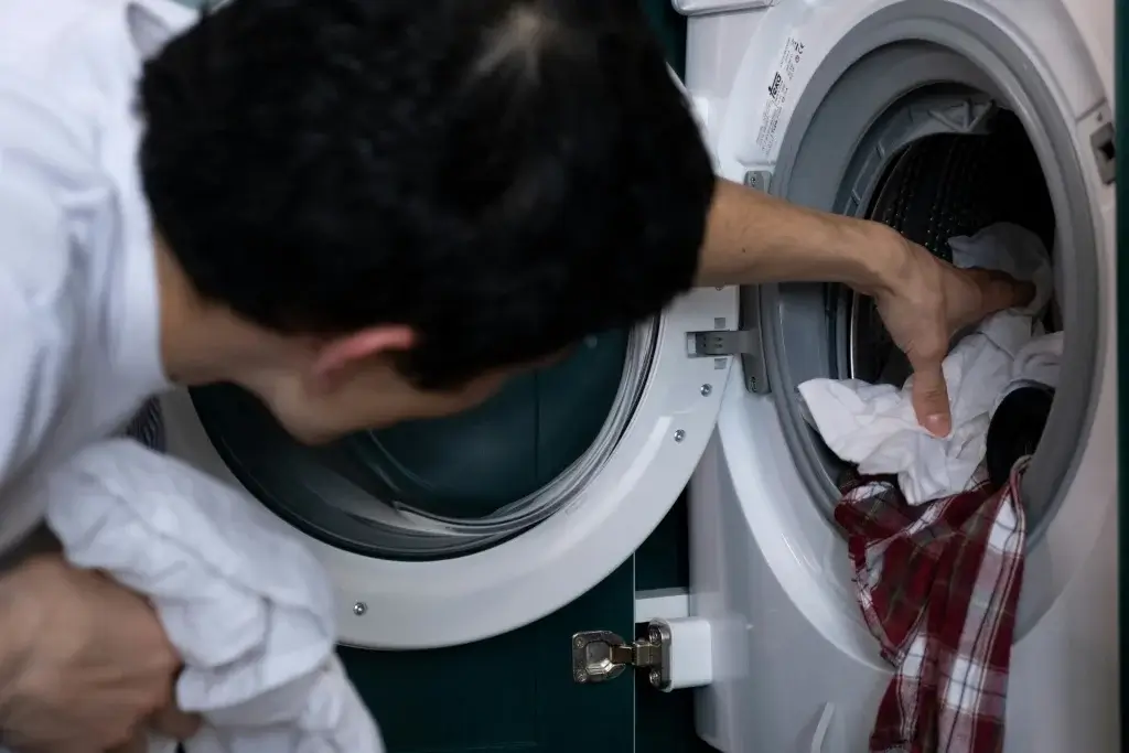 Man loading a washing machine.