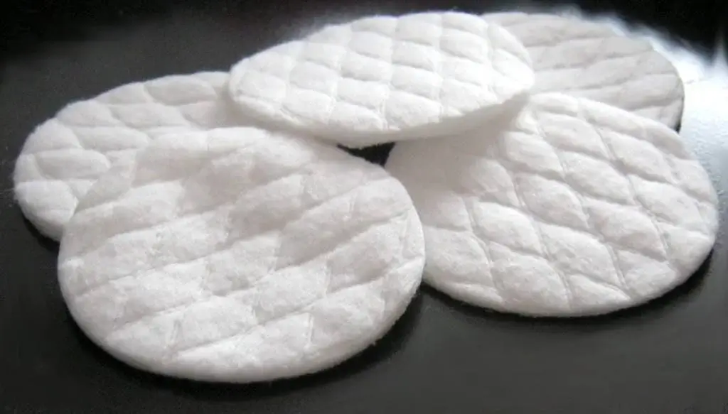 Cotton pads on a black metallic surface.