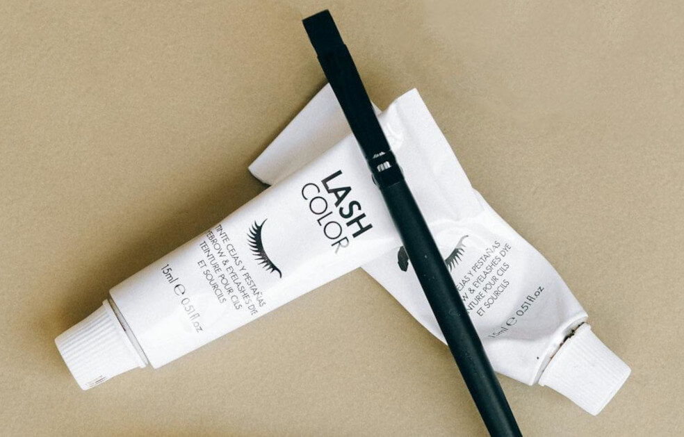 Eyelash tinting for men: two tubes of lash color cream with applicator brush for home use.