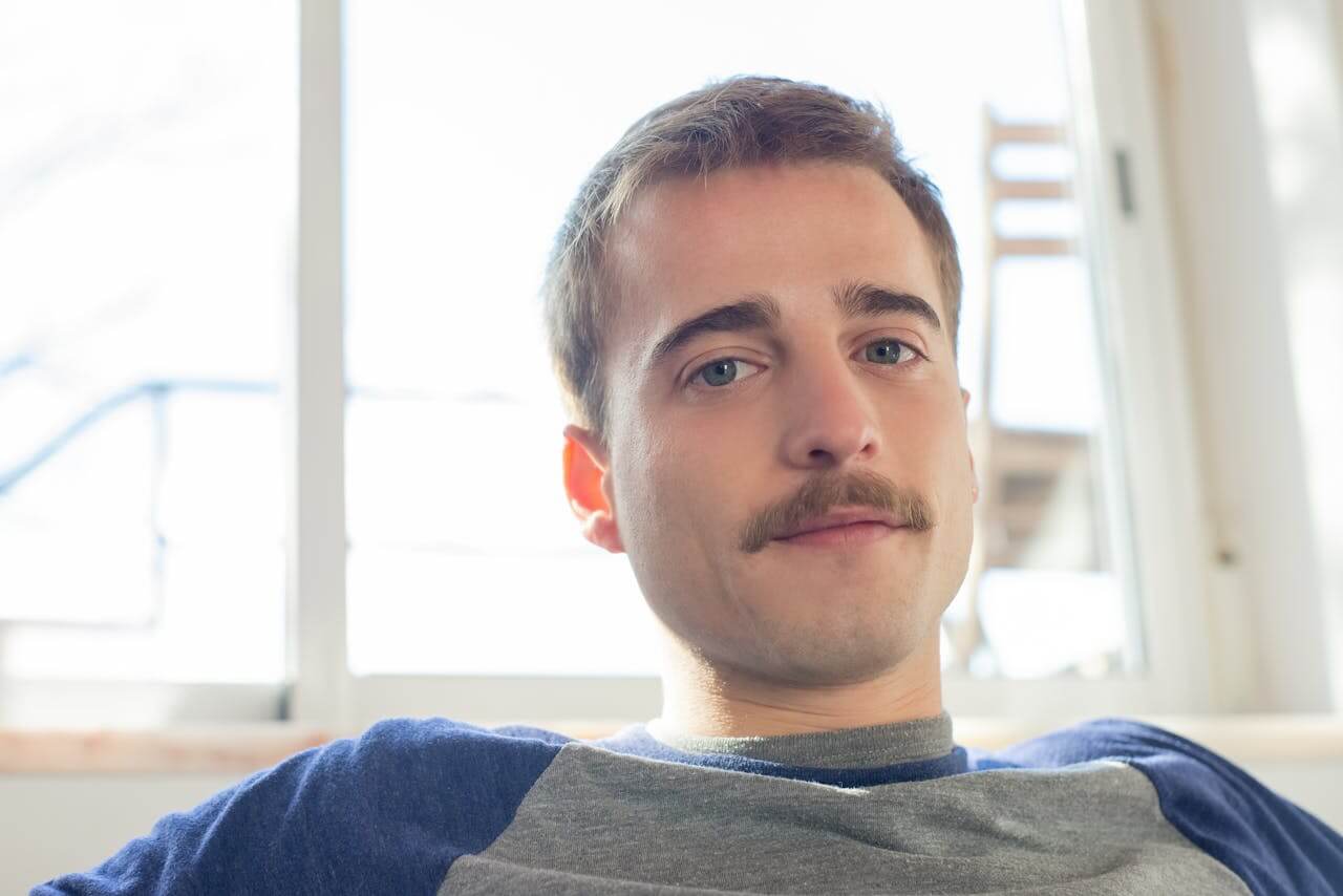 A young man with a stand-alone mustache.