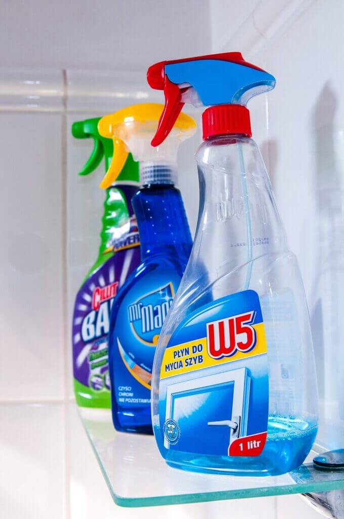 Colorful spray bottles of commercial cleaners—highlighting the aerosol risks compared to vinegar and dish soap.