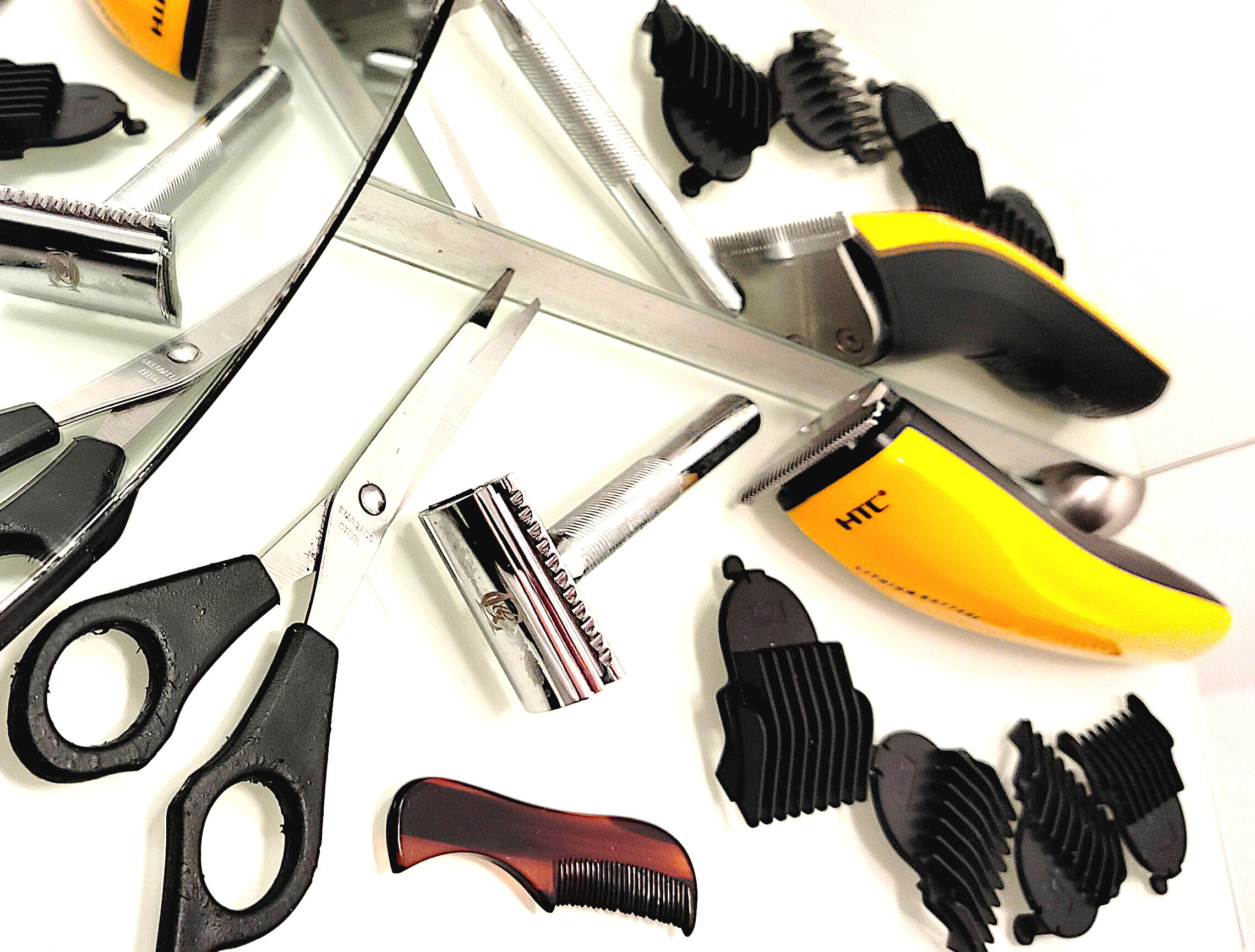 Men’s grooming tools arranged for home haircutting—includes safety razor, clippers, guards, scissors, and comb. A practical setup for self-care or gift ideas for men.