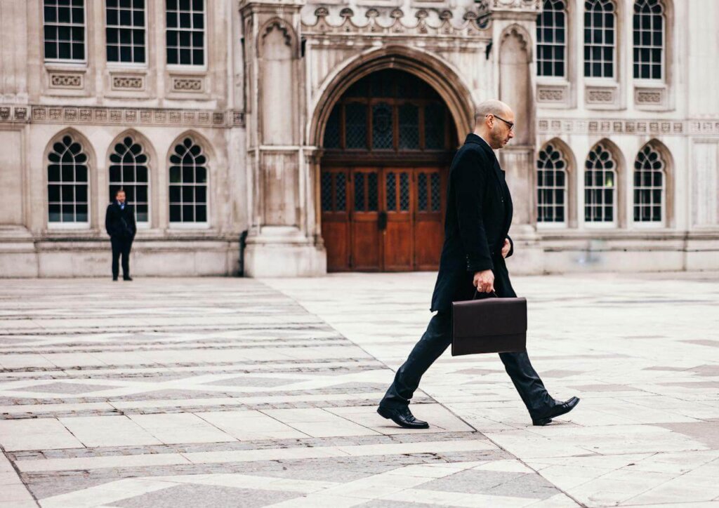 Man commuting on foot in urban setting, carrying a briefcase, a simple way to increase NEAT.