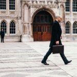 Man commuting on foot in urban setting, carrying a briefcase, a simple way to increase NEAT.
