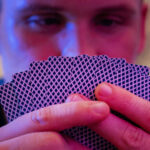 A man studying playing cards with a poker face.