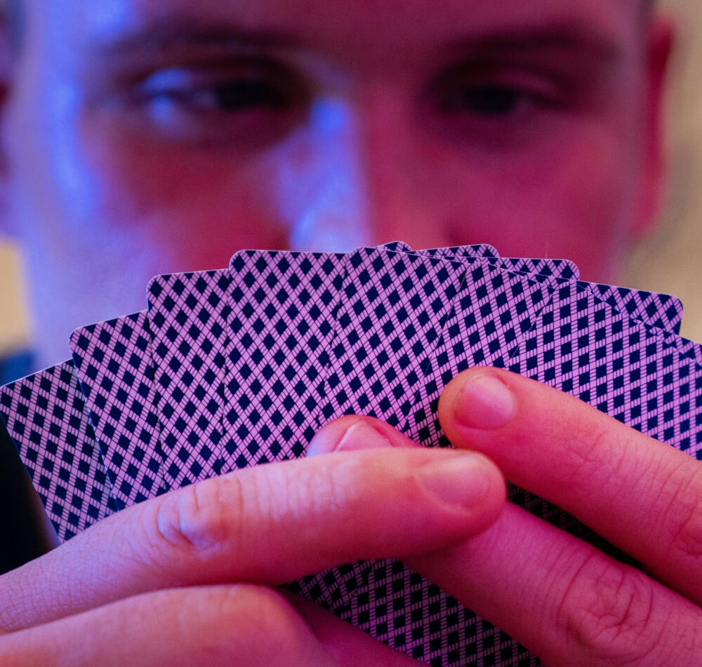 A man studying playing cards with a poker face.