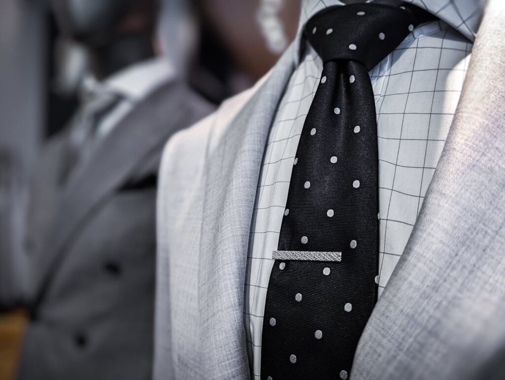 A tie bar illustrating how it keeps the tie in place to prevent it swinging forward, especially while eating.