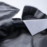 Black and white striped shirt matched with a black textured tie.