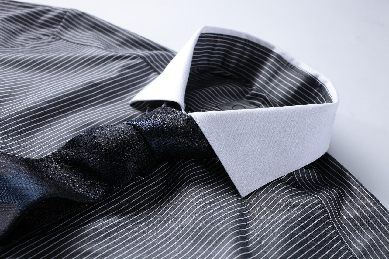 Black and white striped shirt matched with a black textured tie.