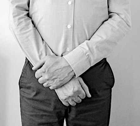 Man with his hands neatly in front, below the waist.