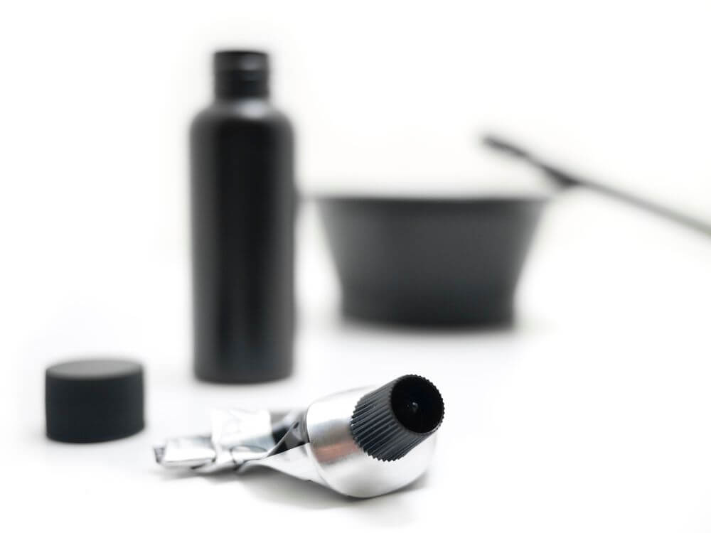 A bottle of peroxide developer, a tube of colorant, and and tinting bowl with brush.